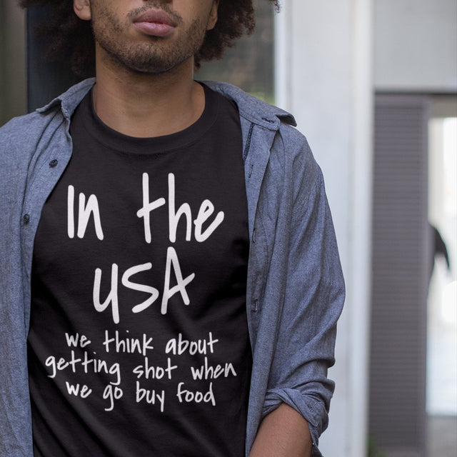 in-the-usa-we-think-about-getting-shot-when-we-go-buy-food-usa-tee-government-t-shirt-shot-tee-t-shirt-tee#color_black